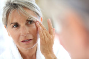Mature woman looking at her reflection in the mirror.